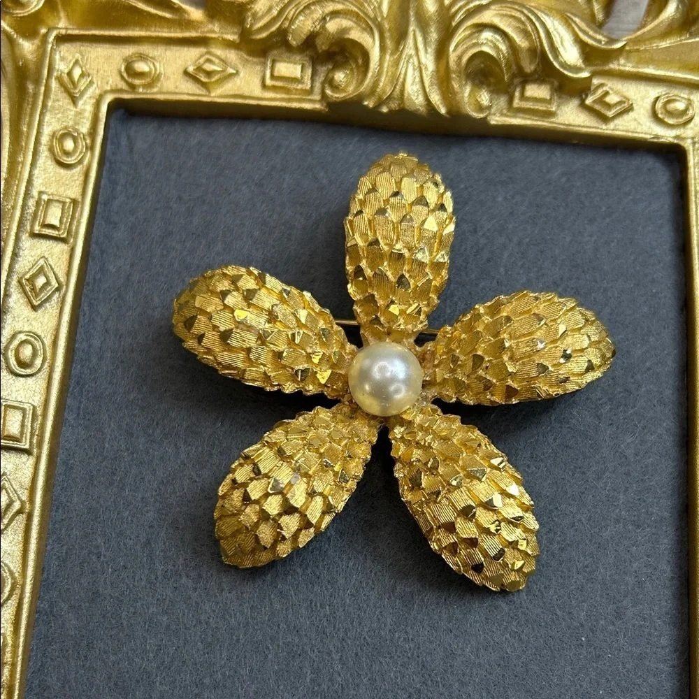 Vintage BSK gold-tone textured flower brooch with a faux pearl center.